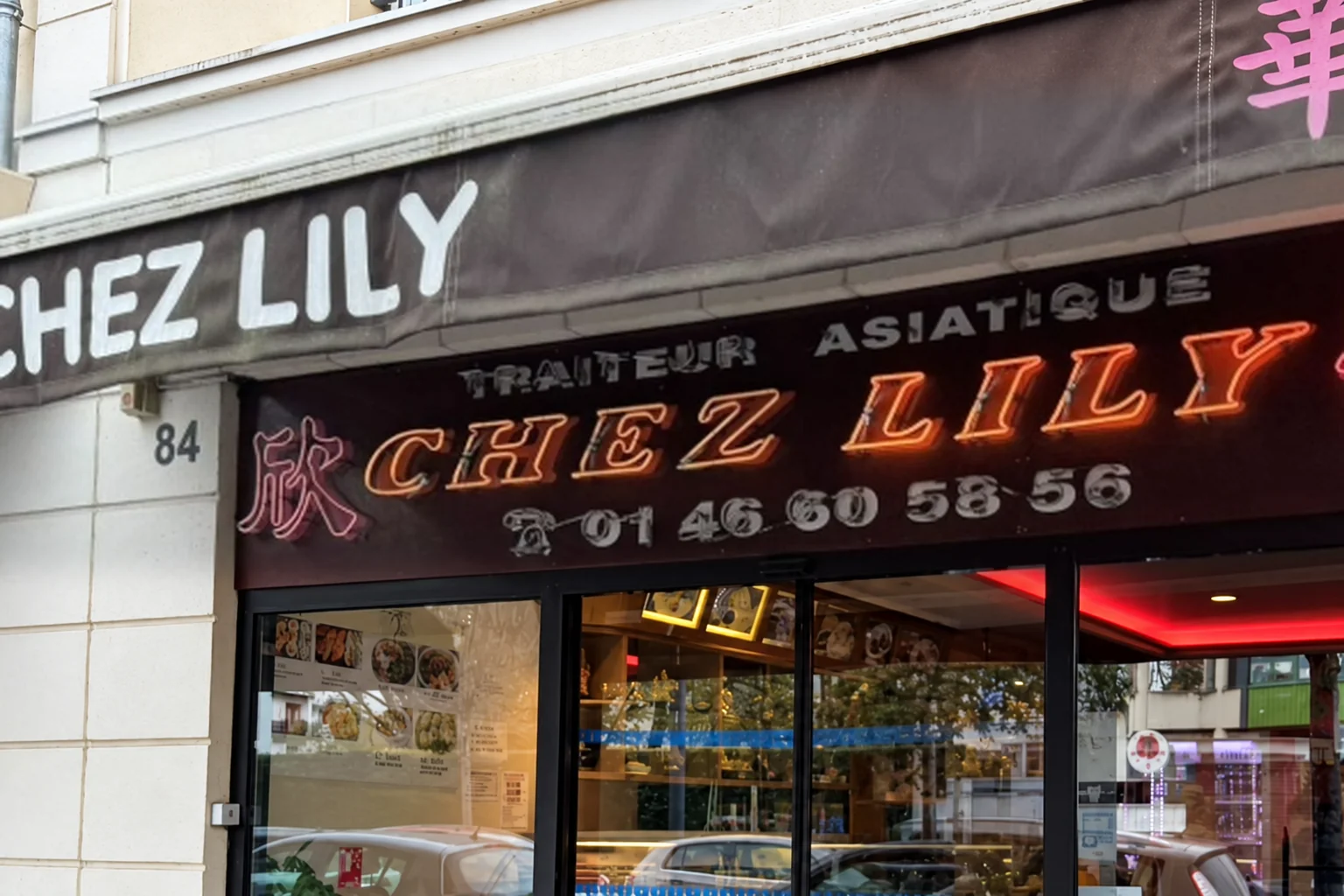 Brown « CHEZ LILY » awning and neon sign with the number 01 46 60 58 56, above the window